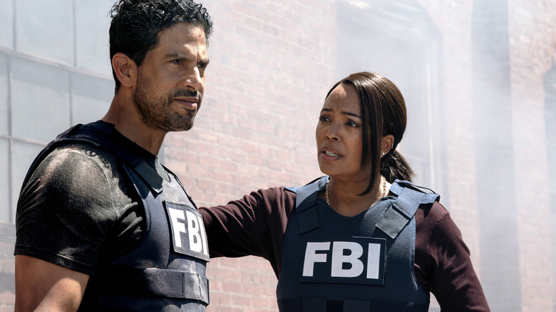 Tara Lewis standing next to and reaching out to Luke Alvez, both wearing FBI vests in Criminal Minds: Evolution