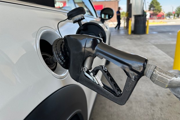 A motorist fills up the fuel tank of a vehicle as another motorist follows suit in the background at a QT gasoline station Wednesday, Aug. 12, 2026, in Greenwood Village, Colo. (AP Photo/David Zalubowski)