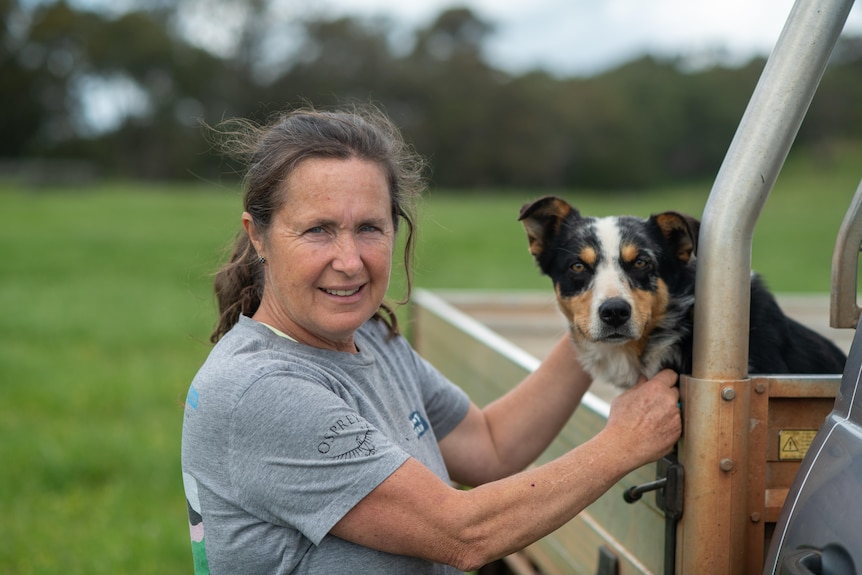 Sally Beggs poses for a photo next to her border collie dog.