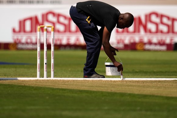 A groundsman works on the pitch during a drinks break on day one.