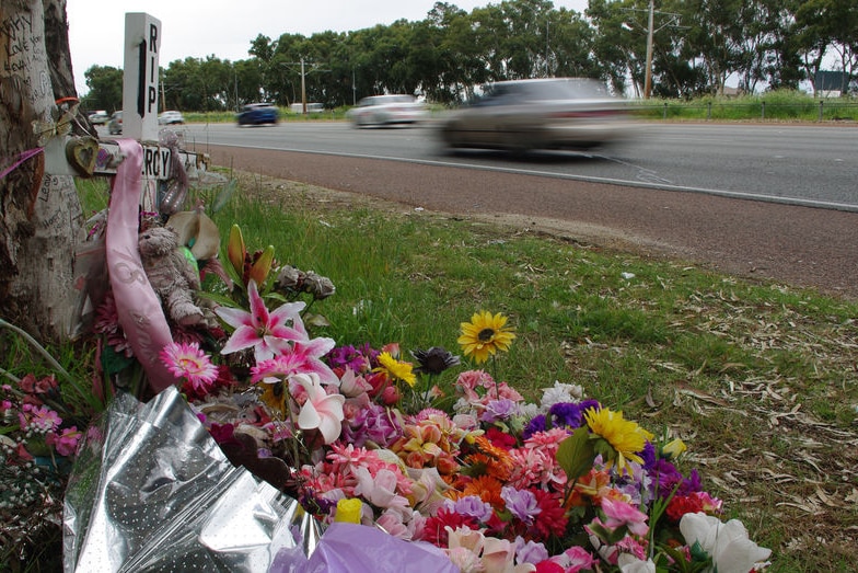 Flowers beside a road marking a death.