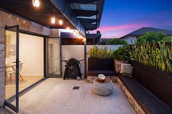 The two-storey townhouse has a covered outdoor area running off the open-plan living area.