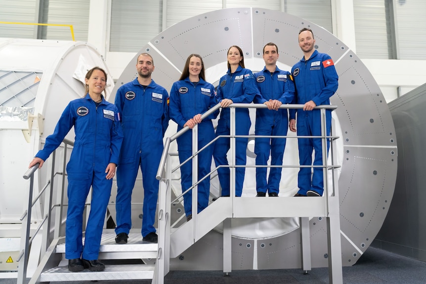 Katherine Bennell-Pegg stands on steps alongside her fellow trainees.