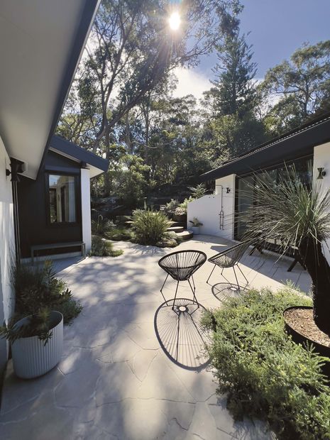 The main bedroom overlooks the sun-trapped courtyard where there is bench seating, access to an outdoor shower and the bush garden.