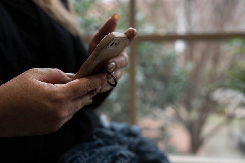 A close up of a lady's hands using a mobile phone.