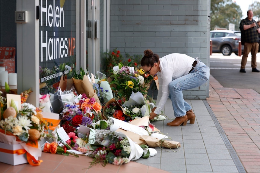 woman in jeans putting flowers at office door