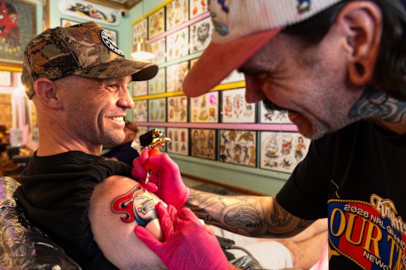 Mick Sharp gets a Newcastle Knights tattoo from artist Dave Ross at Electric Pantera Tattoo Parlour in Newcastle on Thursday.