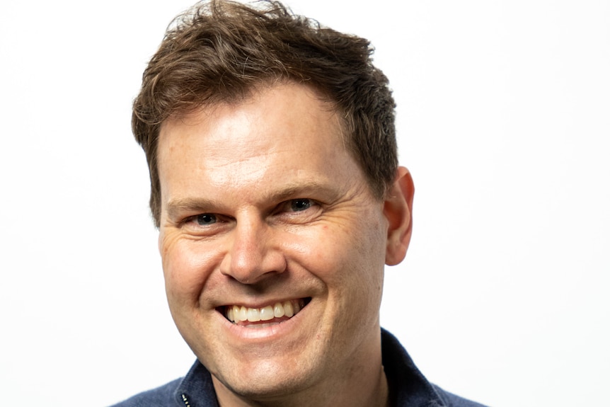 A portrait of a man, smiling.