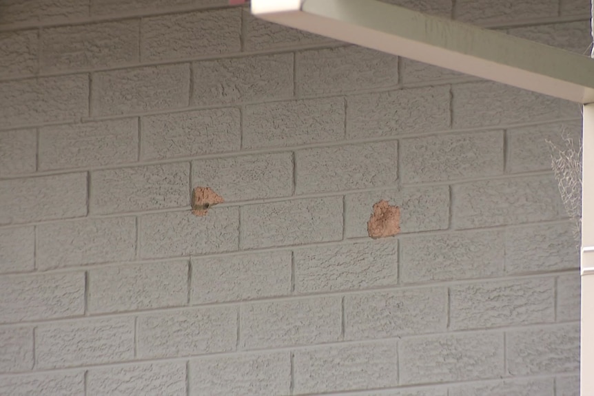 Bullet holes in a red gutter. 