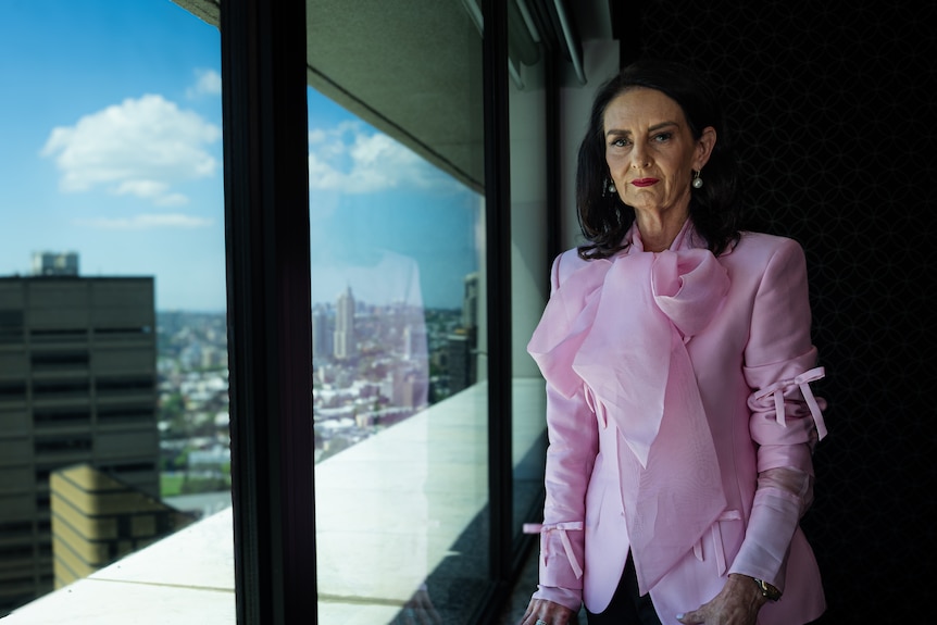 Penny Cable next to a window, in a pink blouse