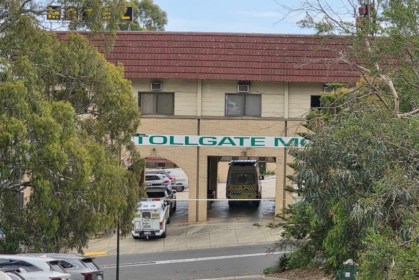 Long-range image of police vehicles sitting inside the Tollgate Motel undercroft