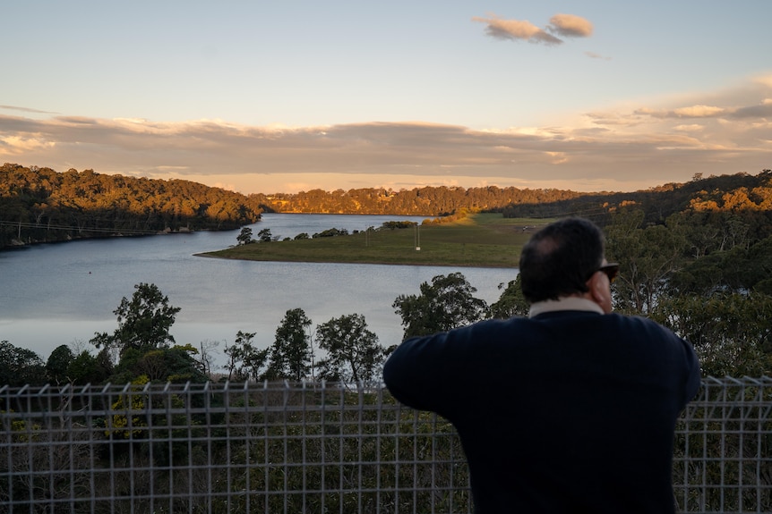 vince stands on a lookout high above the river, which is in the distance