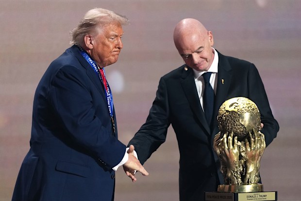 Donald Trump (left) shaking hands with FIFA president Gianni Infantino (right) with the FIFA peace prize in 2025.