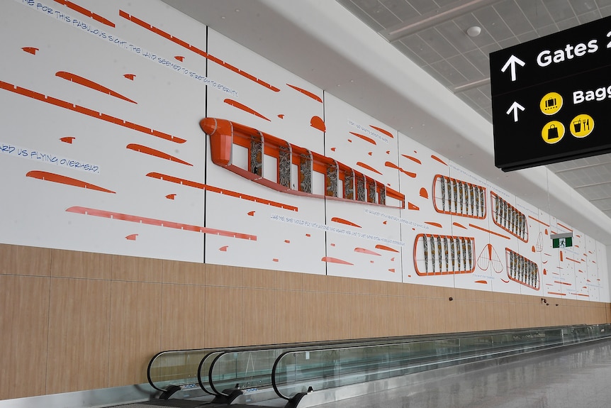 A huge artwork depicting a disassembled biplane on the wall of an airport terminal.