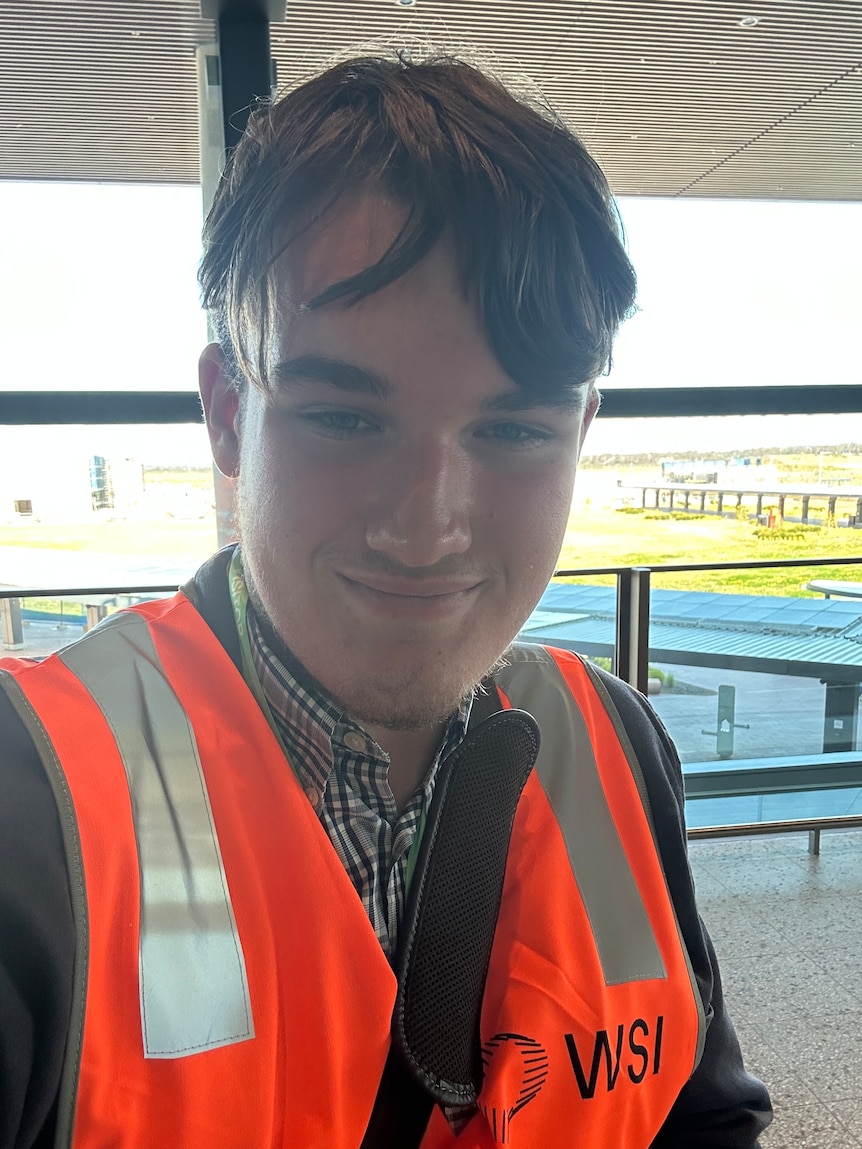 A man poses wearing a hi-vis vest.