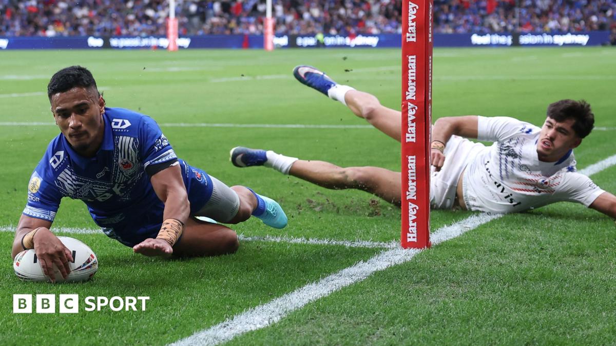 Sua Fa'alogo dives to score a try as a France defender lies on the ground watching him