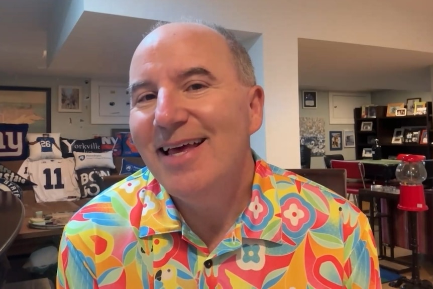 Dan Ives speaking wearing a brightly coloured shirt.