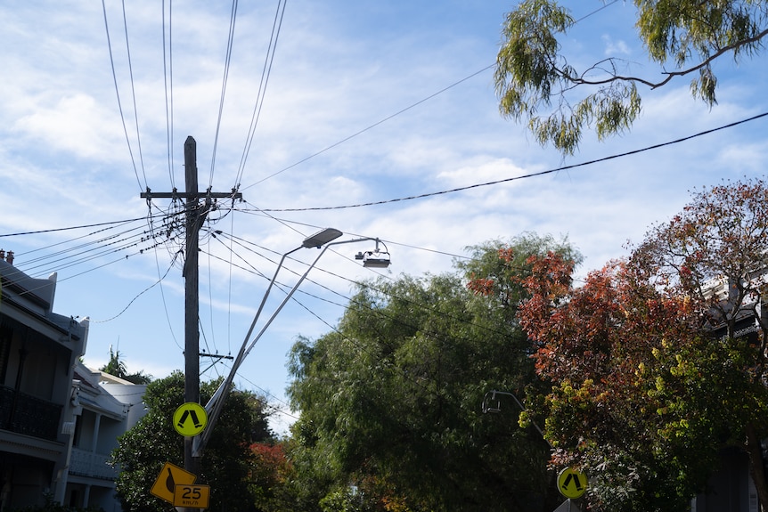 Power pole and lines against a bright blue sky