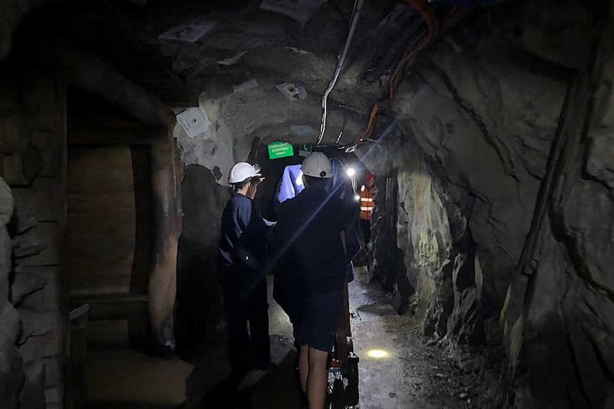 People move through a dark tunnel
