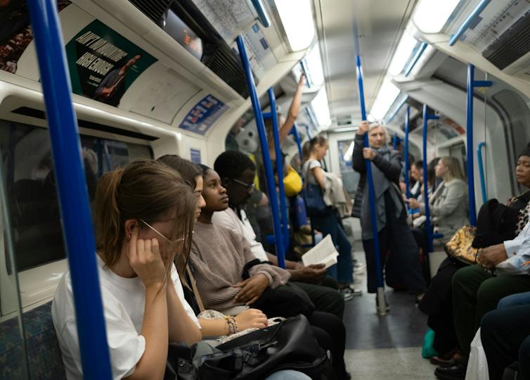 A woman puts her fingers in her ears as protection from the noise of the Victoria Line Tube Train in London.