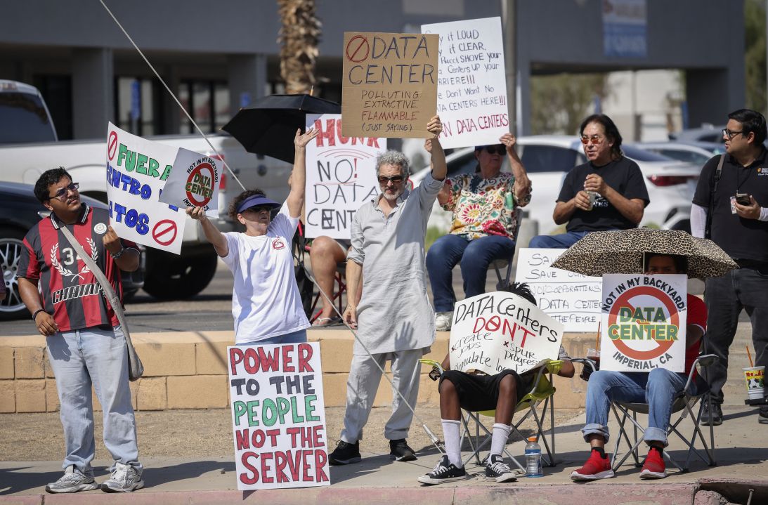 Demonstrators wave signs during a nationwide protest against AI data center expansion in Imperial, California on July 18.