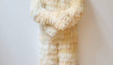a figurative sculpture by Woo Jin Joo covered in white and beige fur