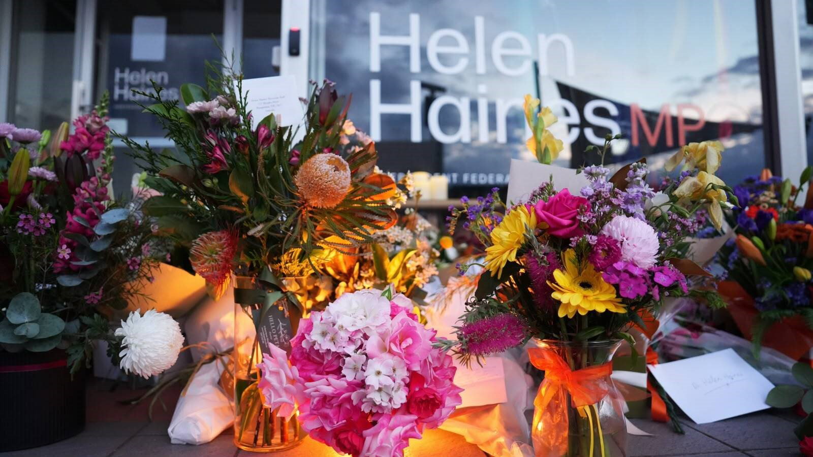 Flowers and candles sit outside Haines's office.