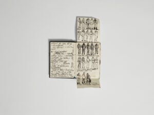 An open notebook containing handwritten notes and costume sketches