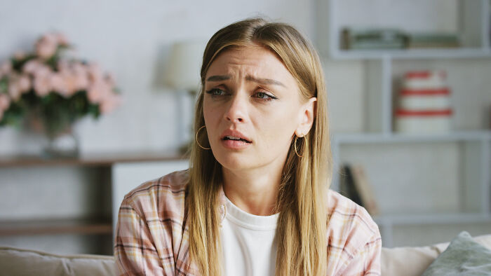 A distressed woman feeling sick sitting indoors after a bad doctor visit