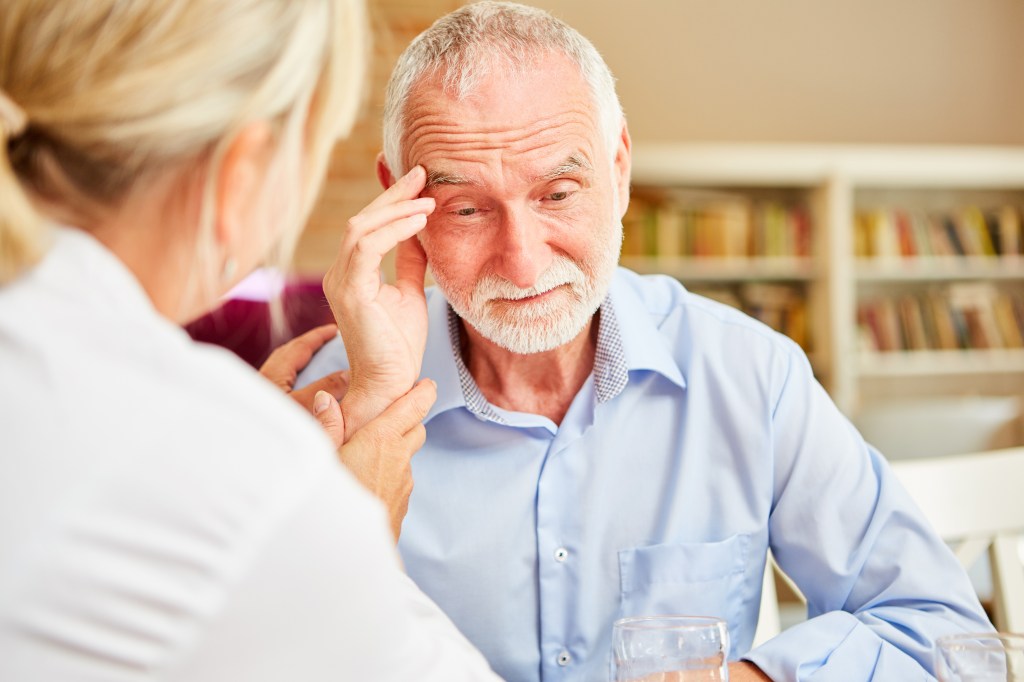 A caring female doctor comforts a senior with dementia or Alzheimer's.