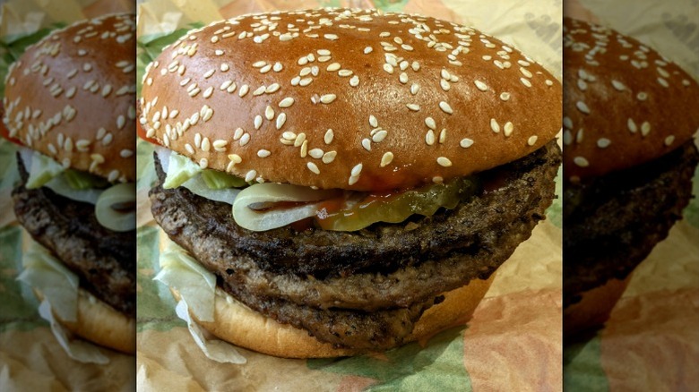 A close-up of a Burger King Triple Whopper burger