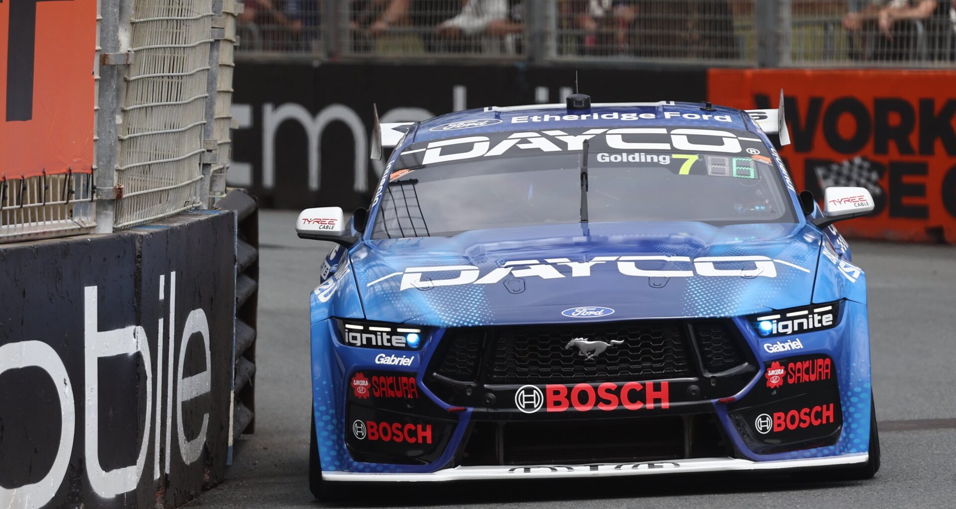 Blue Dayco Ford Mustang Supercar, number 7, rounds a street circuit corner.