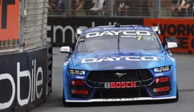 Blue Dayco Ford Mustang Supercar, number 7, rounds a street circuit corner.