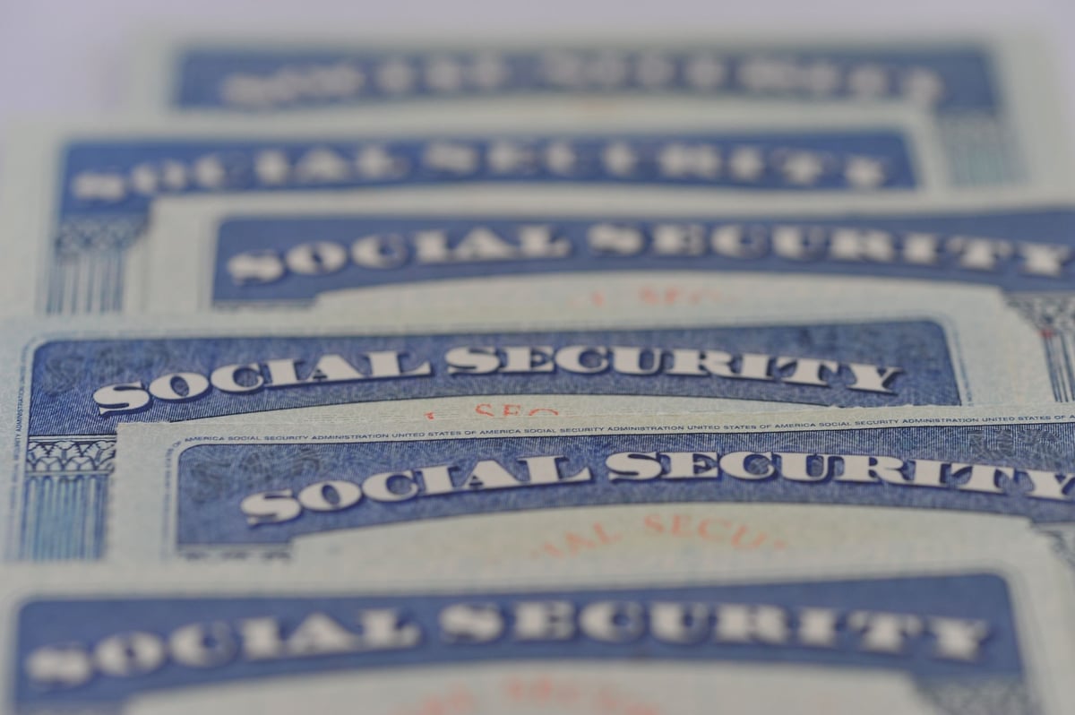 Close-up of overlapping U.S. Social Security cards arranged in rows