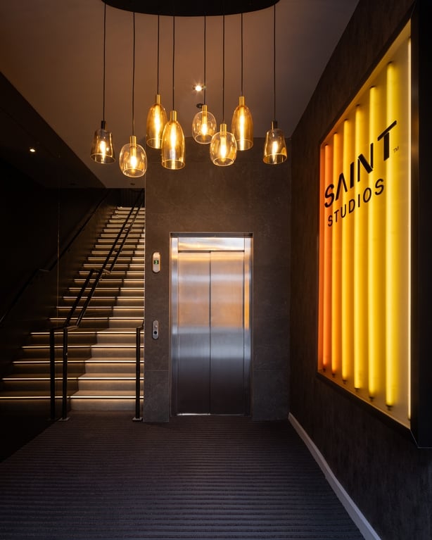 a glamorous entrance to the workout studio with a large yellow LED sign reading 'Saint studios'