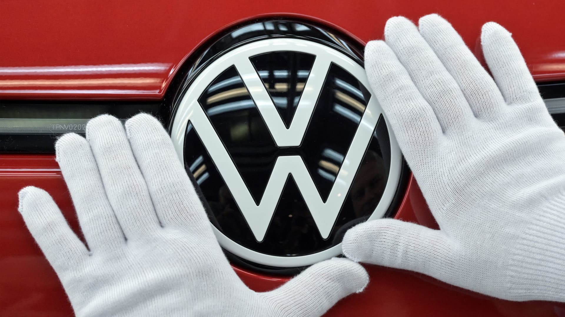 A technician cleans the VW logo during the final inspection of German carmaker Volkswagen's electric ID. 3 car, during a media tour, in Dresden, Germany, May 14, 2025.