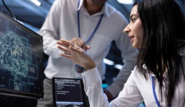 Coworkers using AI tech to fix errors in server farm providing storage. IT staff members in data center using PC to enable artificial intelligence to process datasets for training