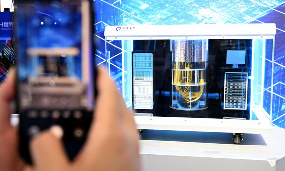 A visitor takes photos of an Origin Wukong superconducting quantum computer model at the 2024 World Manufacturing Convention in Hefei, east China