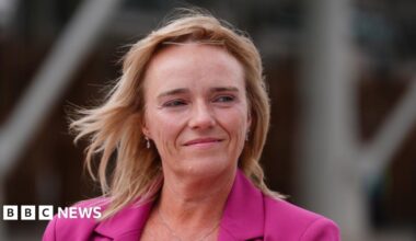 Several women hold banners supporting gender critical nurse Sandie Peggie - the banners saying We Are All Sandie Peggie, better to die on your feet than live forever on your knees and women's rights are not a hate crime