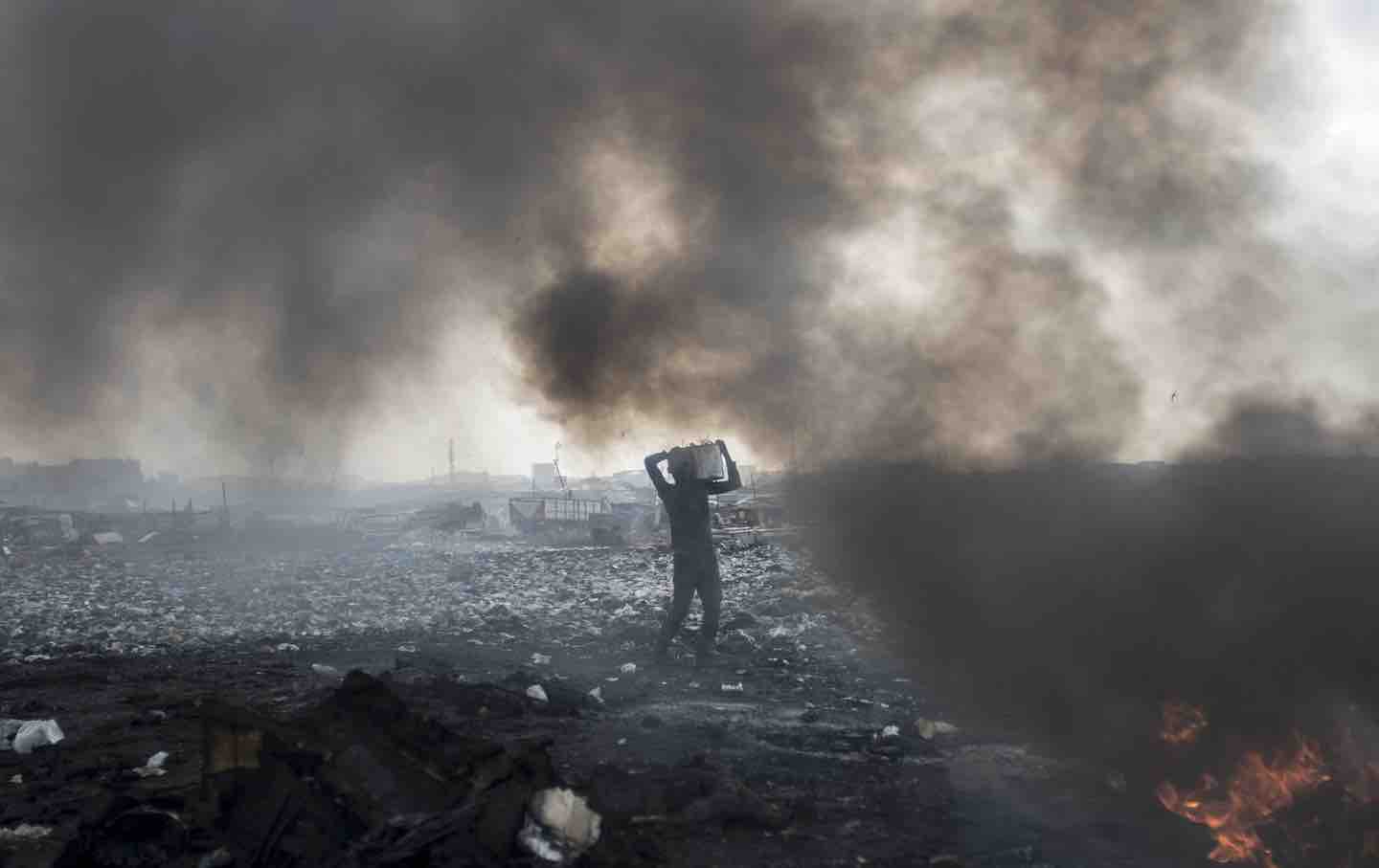 A man carries electronic waste at Agbogbloshie dumpsite in Ghanaian capital of Accra, 2017.
