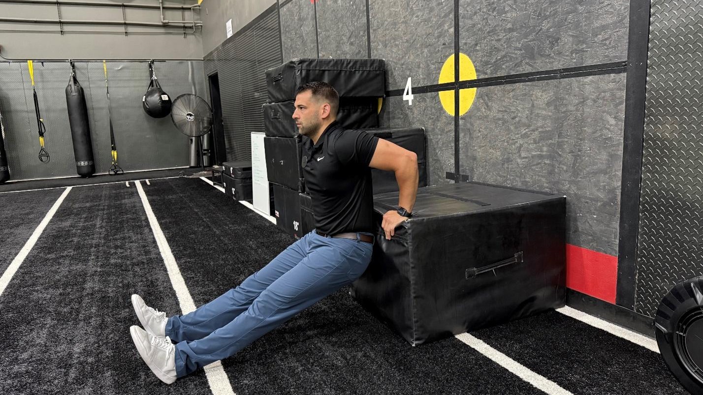man doing exercise tricep dips in the gym