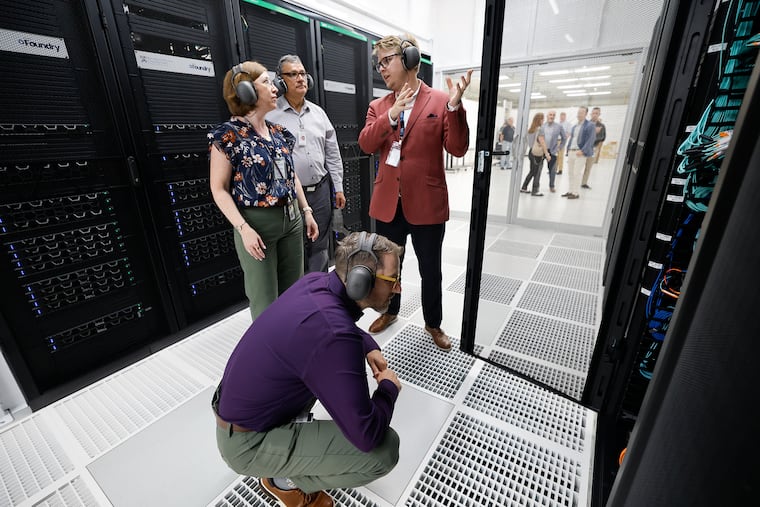 Michael Borda, the associate vice provost for Research and the executive director of Strategic Initiatives, takes a closer look at Betty, the University of Pennsylvania's new supercomputer in Collegeville, as Marylyn Ritchie (rear left), vice dean of Artificial Intelligence and Computing at the Perelman School of Medicine, and Jaime Combariza, executive director of the Penn Advanced Research Computing Center, listen to Kenneth Chaney, the center's associate director of AI and Technology.