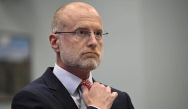 FCC Chairman Brendan Carr adjusts his tie at a Congressional hearing where he was testifying.
