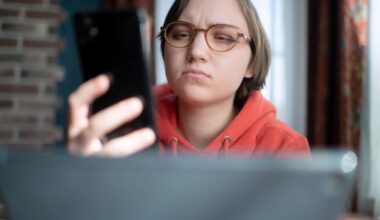 A person looks at their phone with a look of confusion.