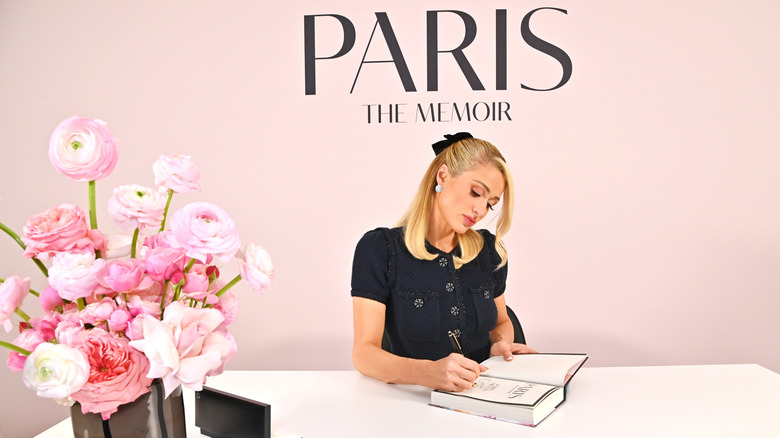 Paris Hilton signing a copy of her memoir
