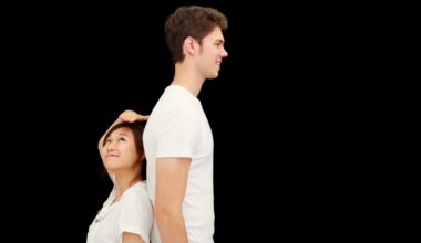 a short woman stands back-to-back with a much taller man