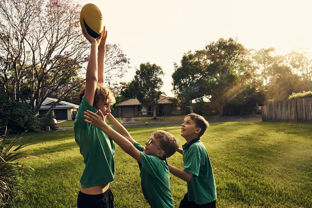 Three brothers playing with a ball