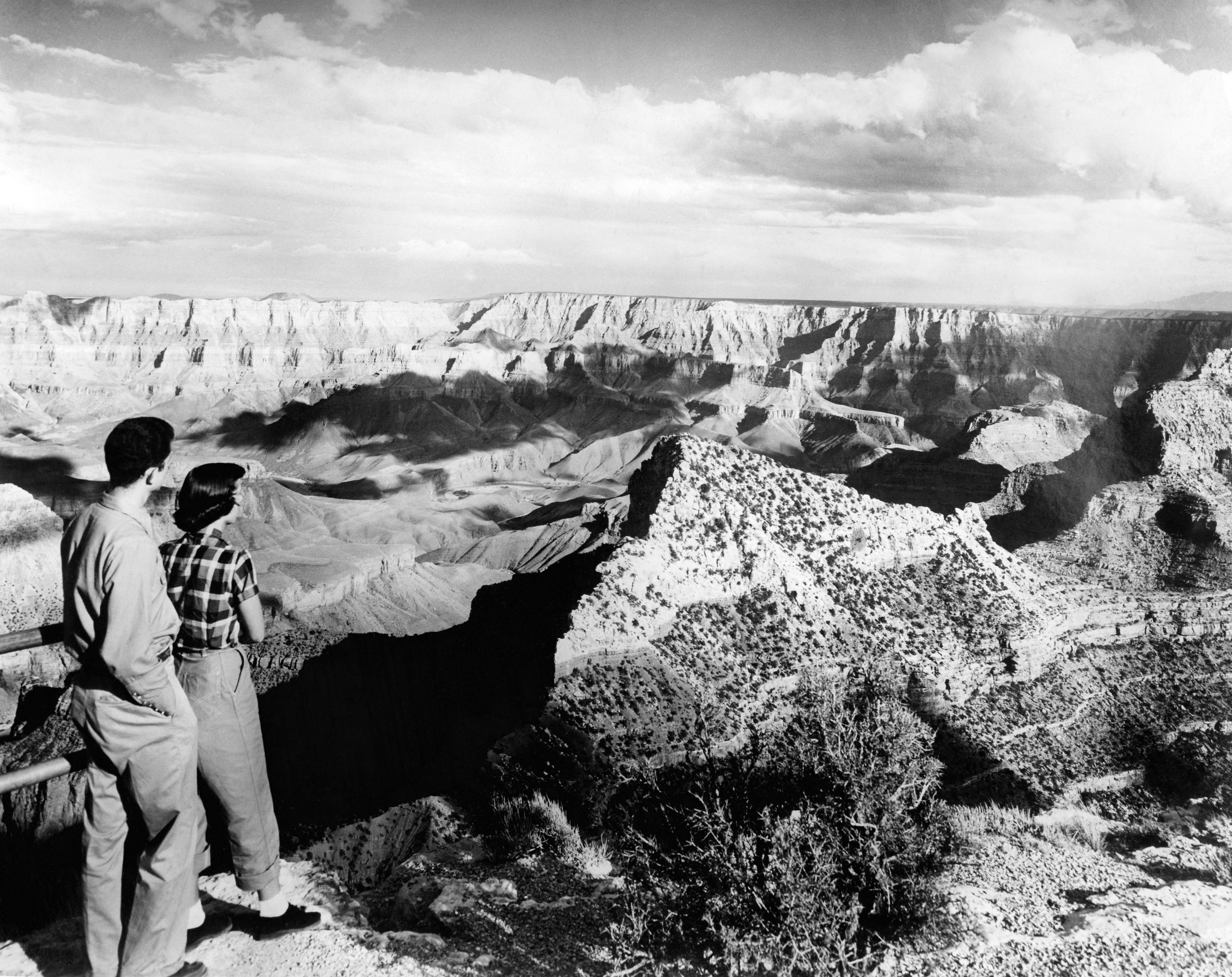 Black and white photo of a couple viewing the Grand Canyon.