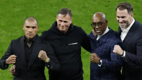 Action Images/Reuters Four men with clenched fists standing next to each other on grass. Three of them are wearing dark suits and the other man is wearing a black tracksuit.