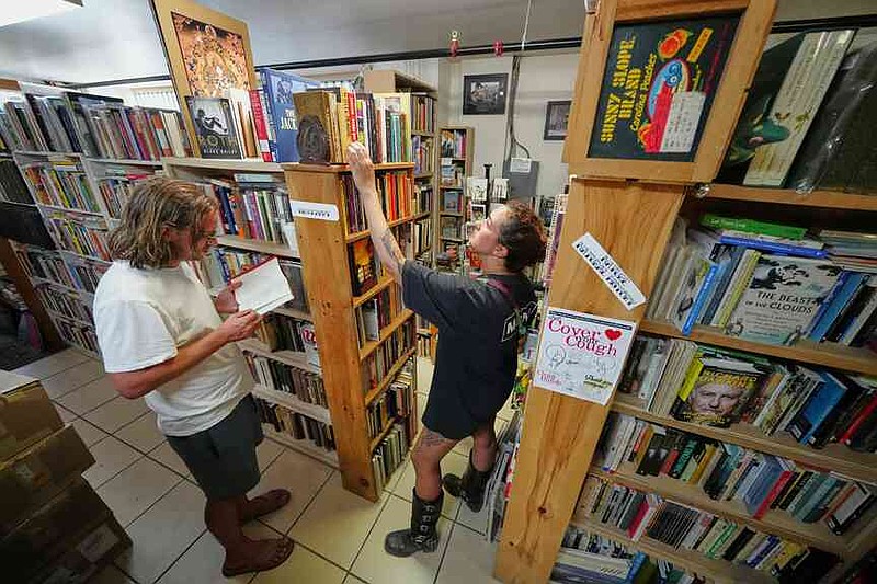 Andrew Higgins and Savannah Shealy peruse the biography section of the Green Hand Bookstore in Portland, Maine, on Thursday, Aug. 7, 2025. (AP Photo/Robert F. Bukaty)